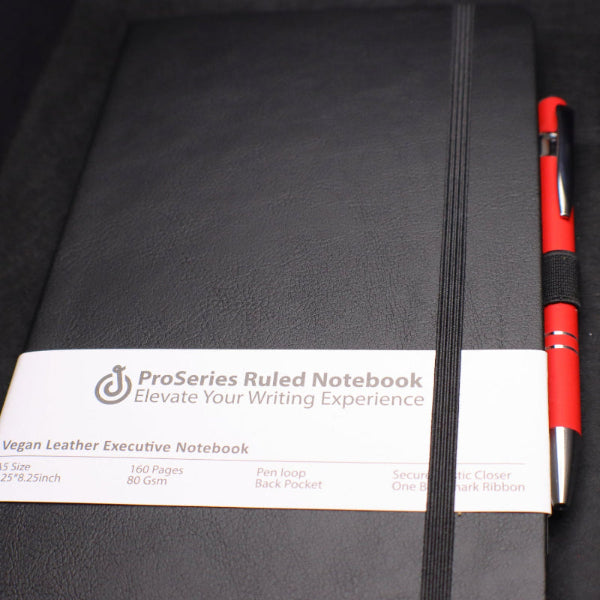 Black ruled notebook with a red pen on a black background