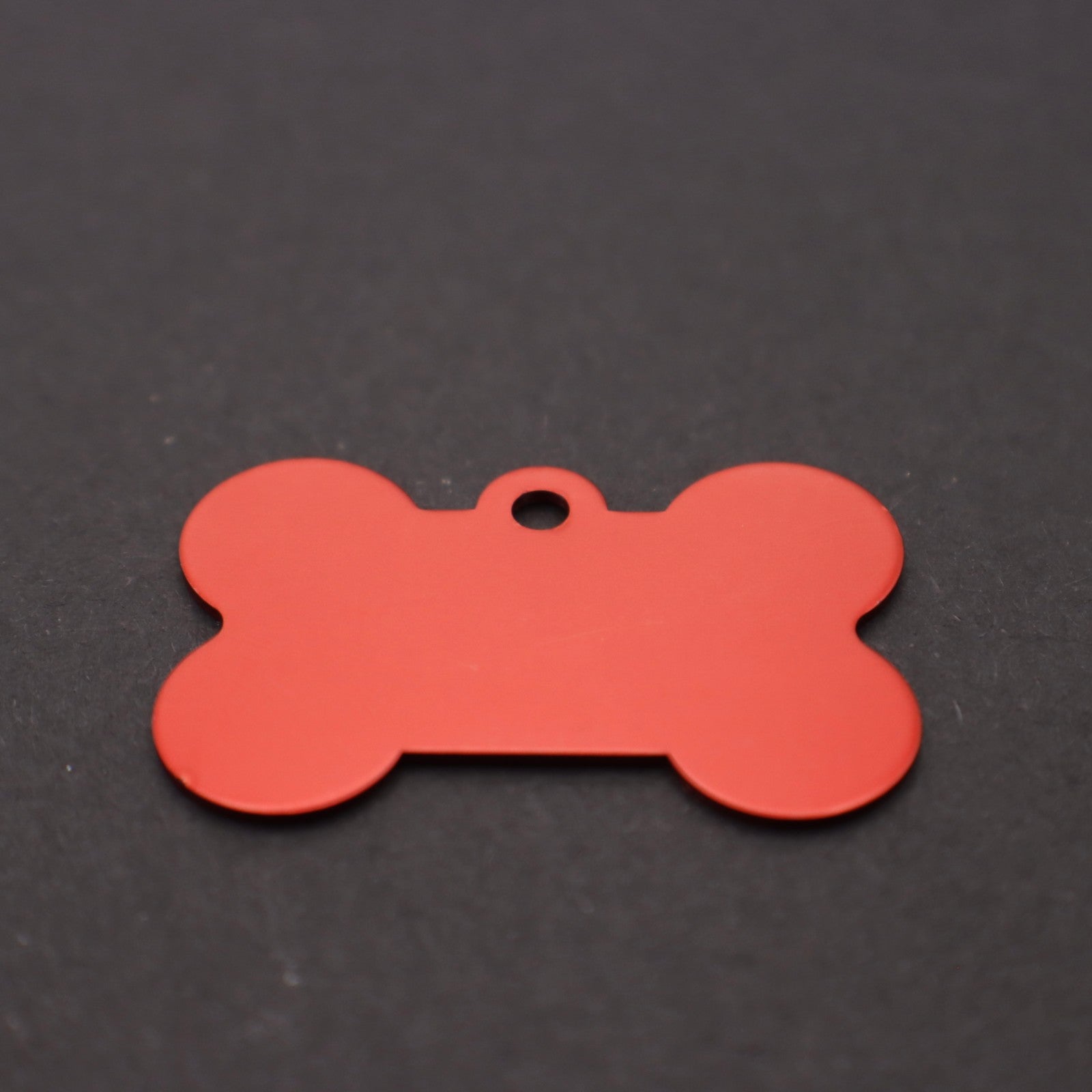 Red bone-shaped tag on a black background