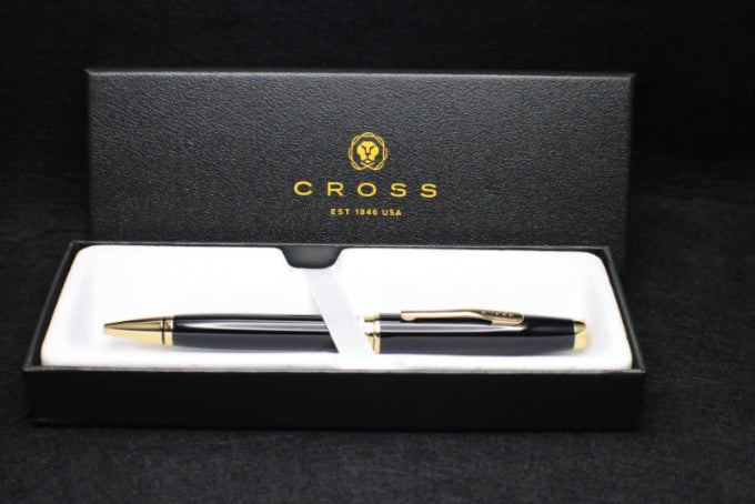 Pen set with a Cross logo in a black box on a black background