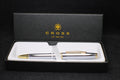 Cross pen set with white body and gold accents in a black box on a black background