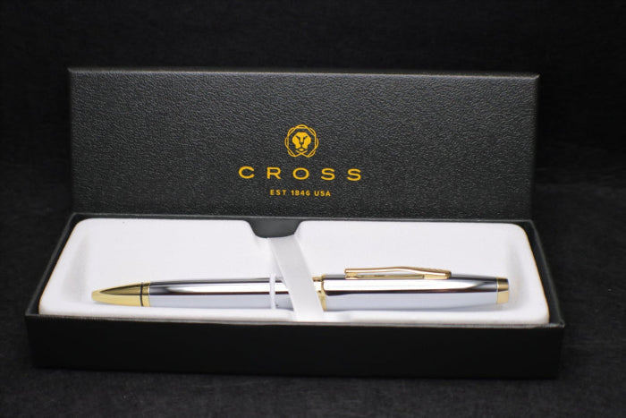 Cross pen set with white body and gold accents in a black box on a black background
